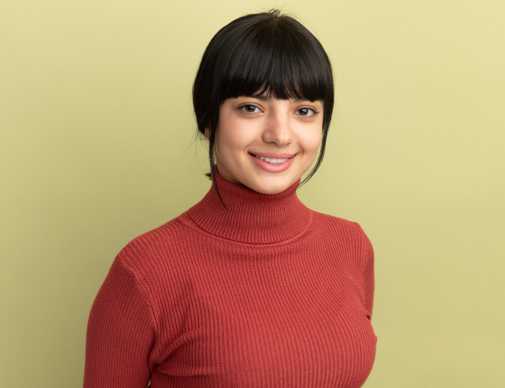 Studio headshot of a woman in a red turtleneck